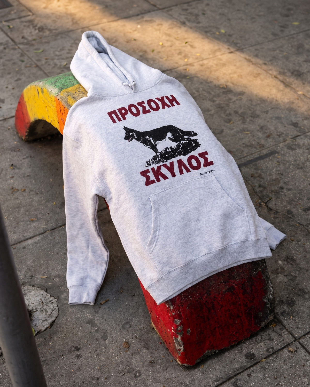 Beware of Dog hoodie laid on a painted curb ledge on the Sunset Boulevard sidewalk